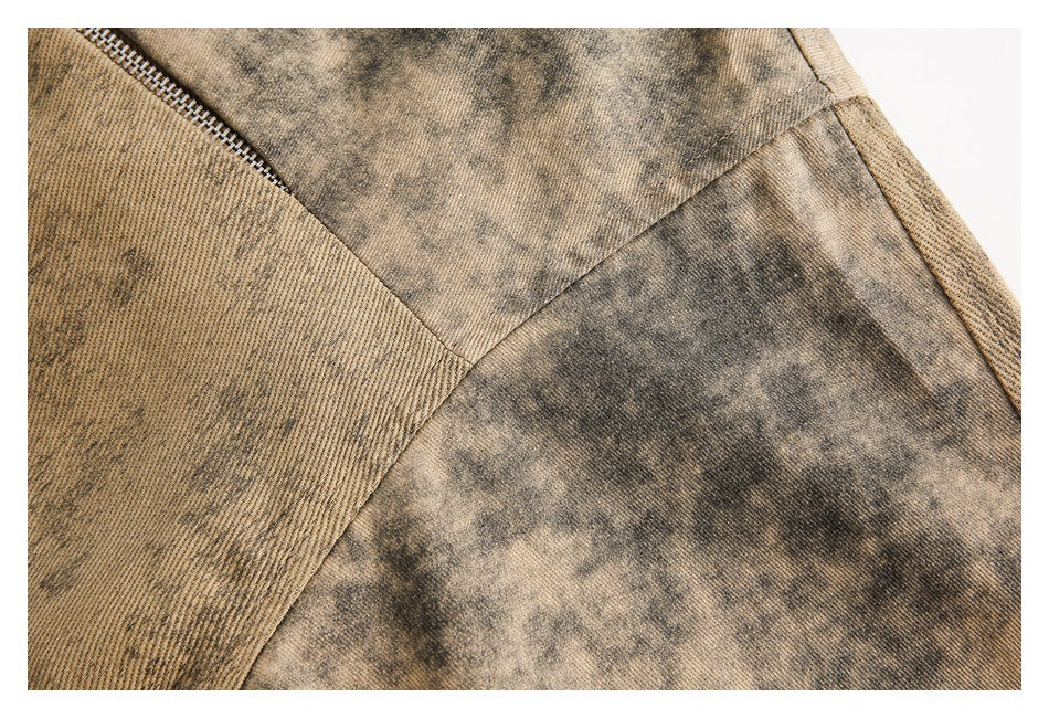 Close-up of tan and dark mottled jacket fabric panels and their intersecting seams.