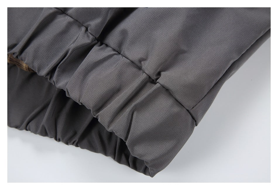 Close-up of a dark gray garment hem with gathered elastic stitching.