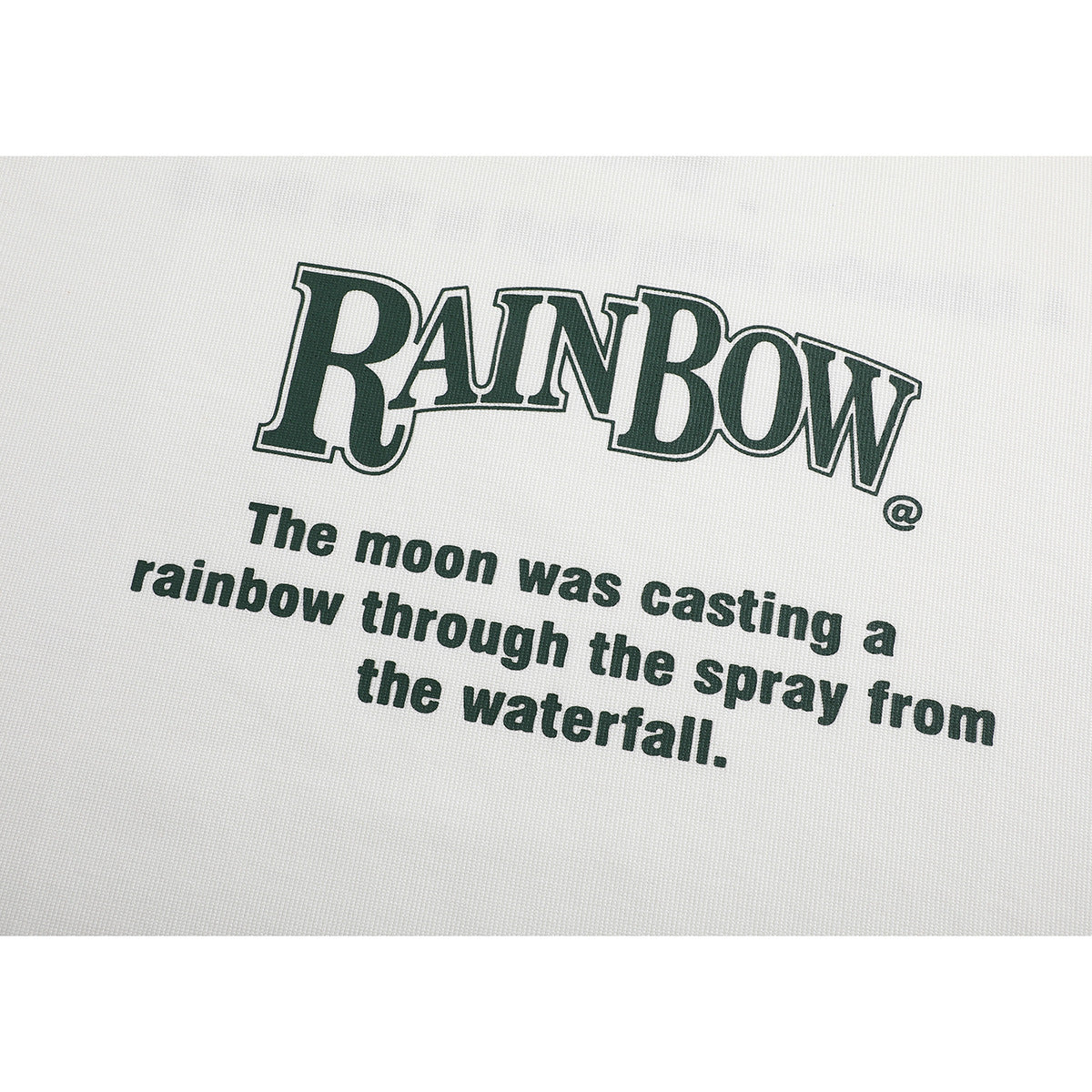Close-up of dark green English lettering and a quote printed on an off-white T-shirt.
