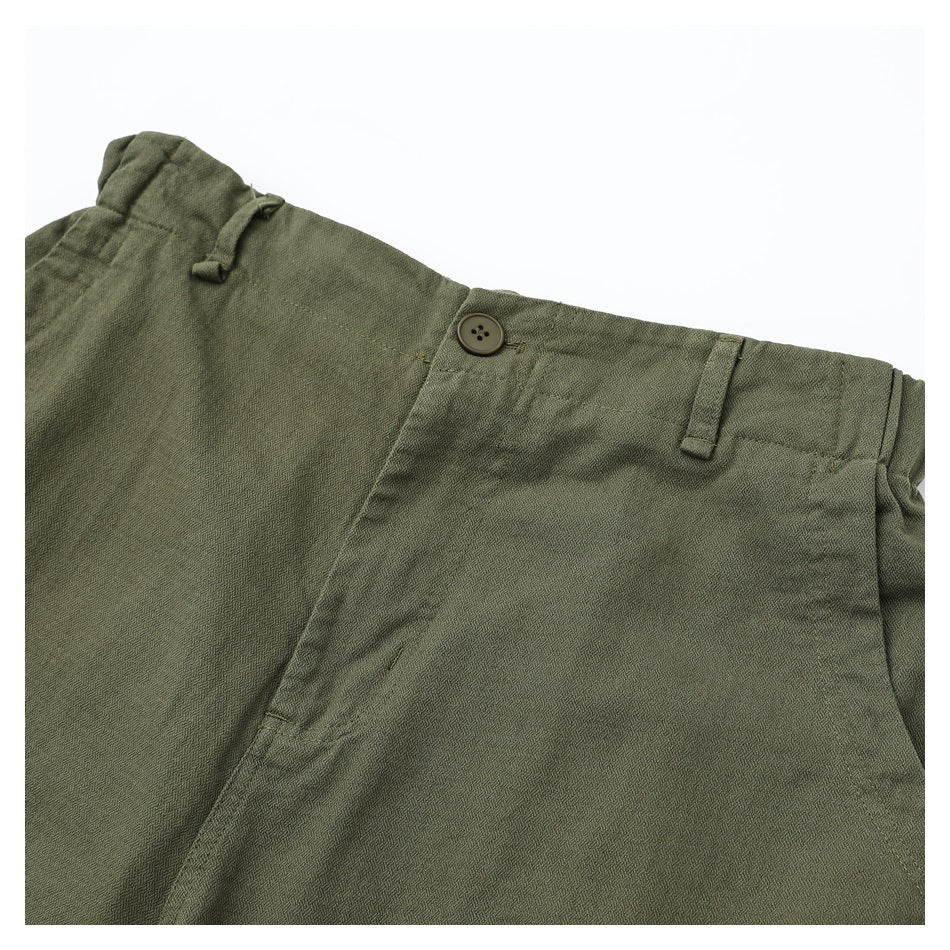 Close-up of olive pants showing the waistband, button, belt loop, fly, and fine fabric texture.