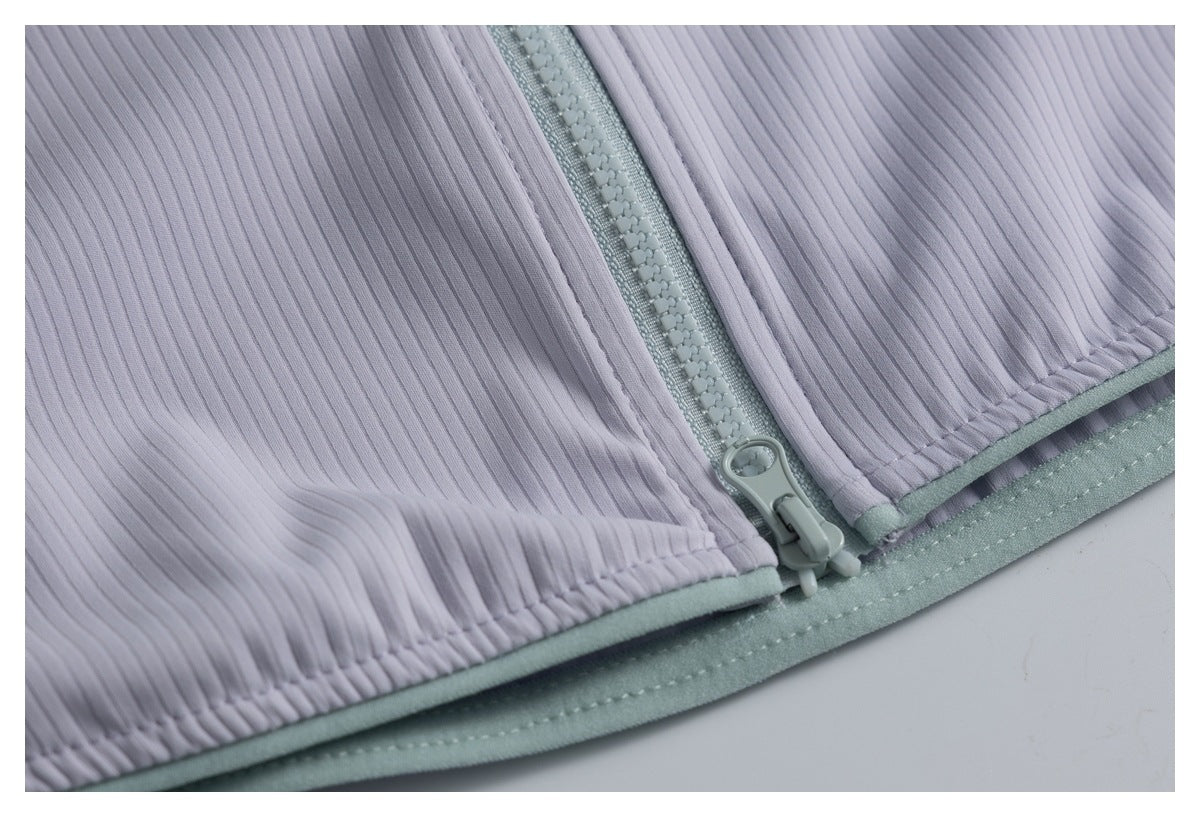 Close-up of the lavender ribbed garment’s lower front zipper, hem, and pale aqua trim.