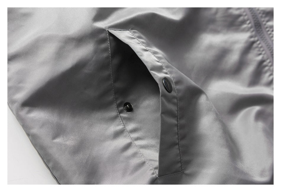 Close-up of a gray garment with a snap-button closure and stitched placket.