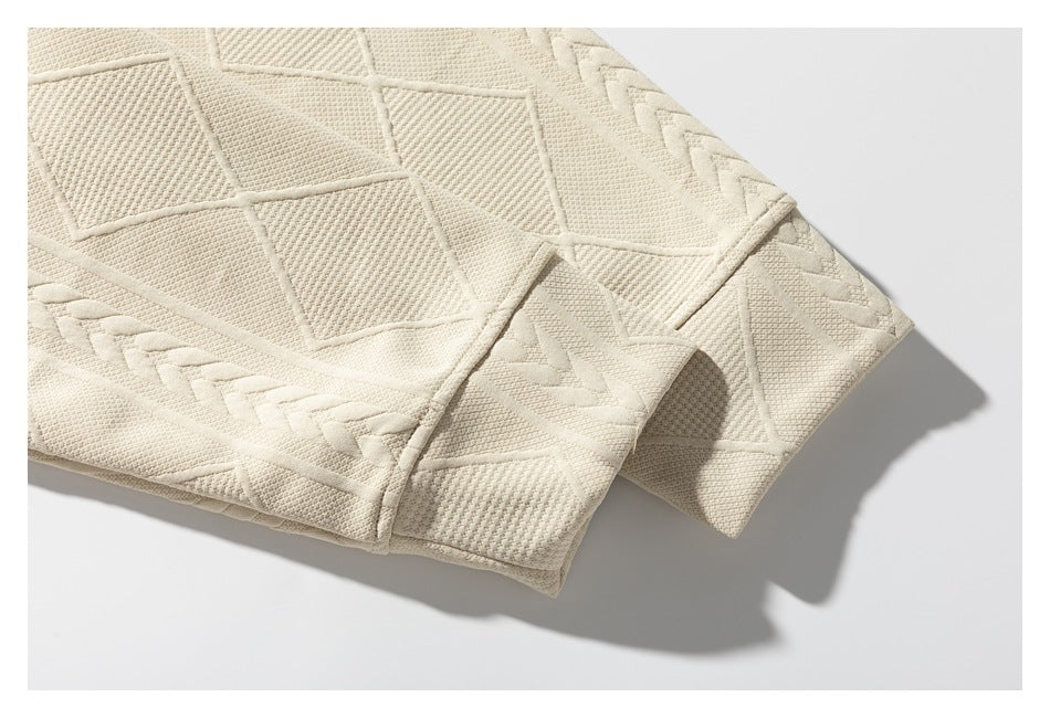 Close-up of a finished edge on the cream sweater, with textured geometric knit and braided bands.