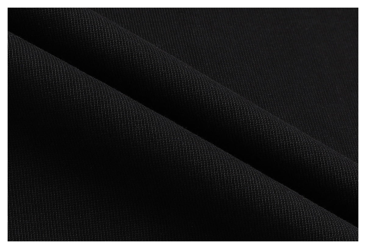 Macro view of black fabric draped in folds, showing its knit texture.