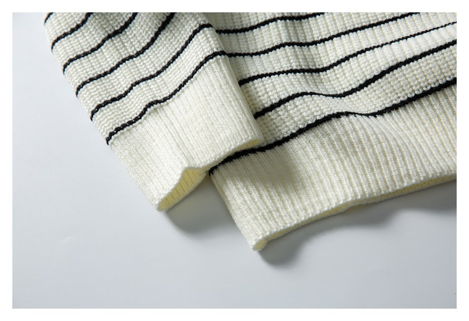 Close-up of the ivory sweater's striped sleeve cuff and ribbed hem.