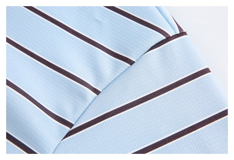 Close-up of light blue textured fabric with dark brown and white stripes folded over itself.