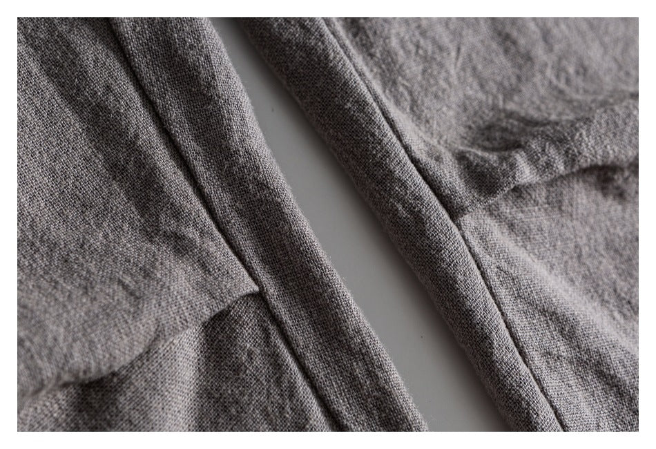 Close-up of gray garment fabric and overlapping stitched edges.