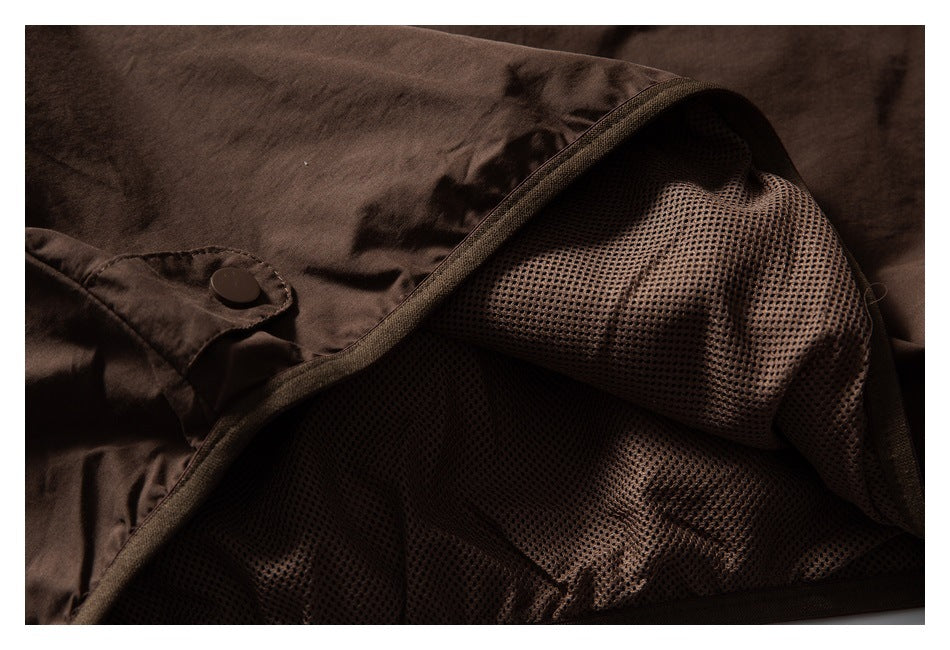 Close-up of the dark brown jacket's mesh lining and snap-tab detail.