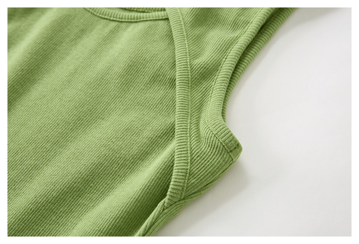 Close-up of light green ribbed fabric with a curved bound edge and visible stitching.