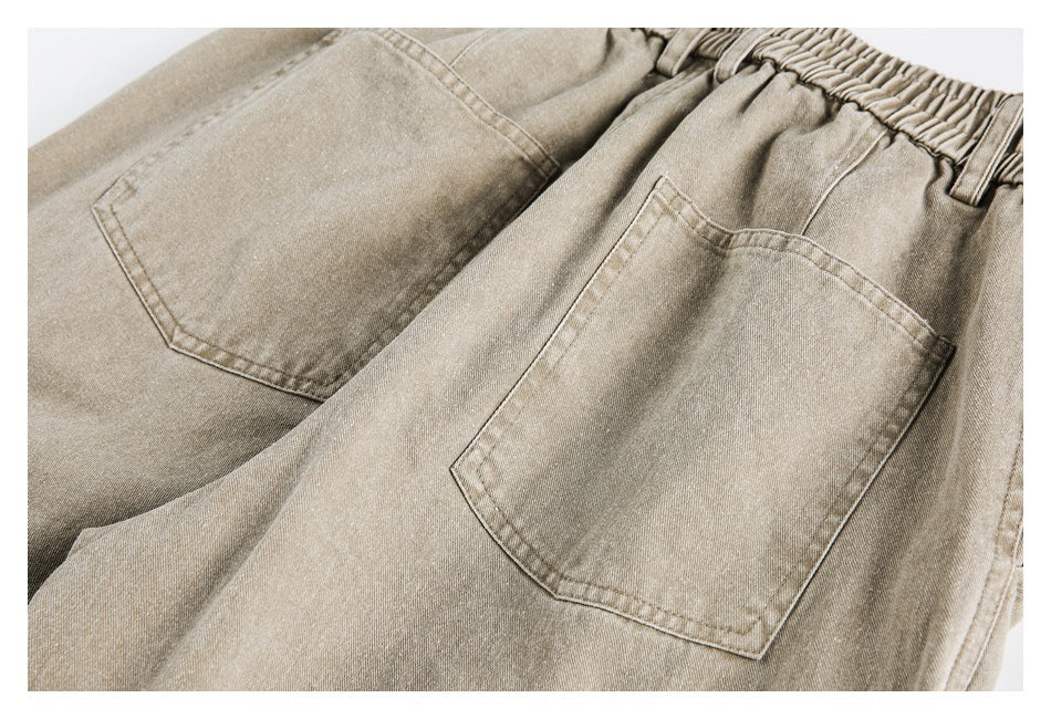 Close-up of beige trousers showing two back pockets and an elastic waistband.