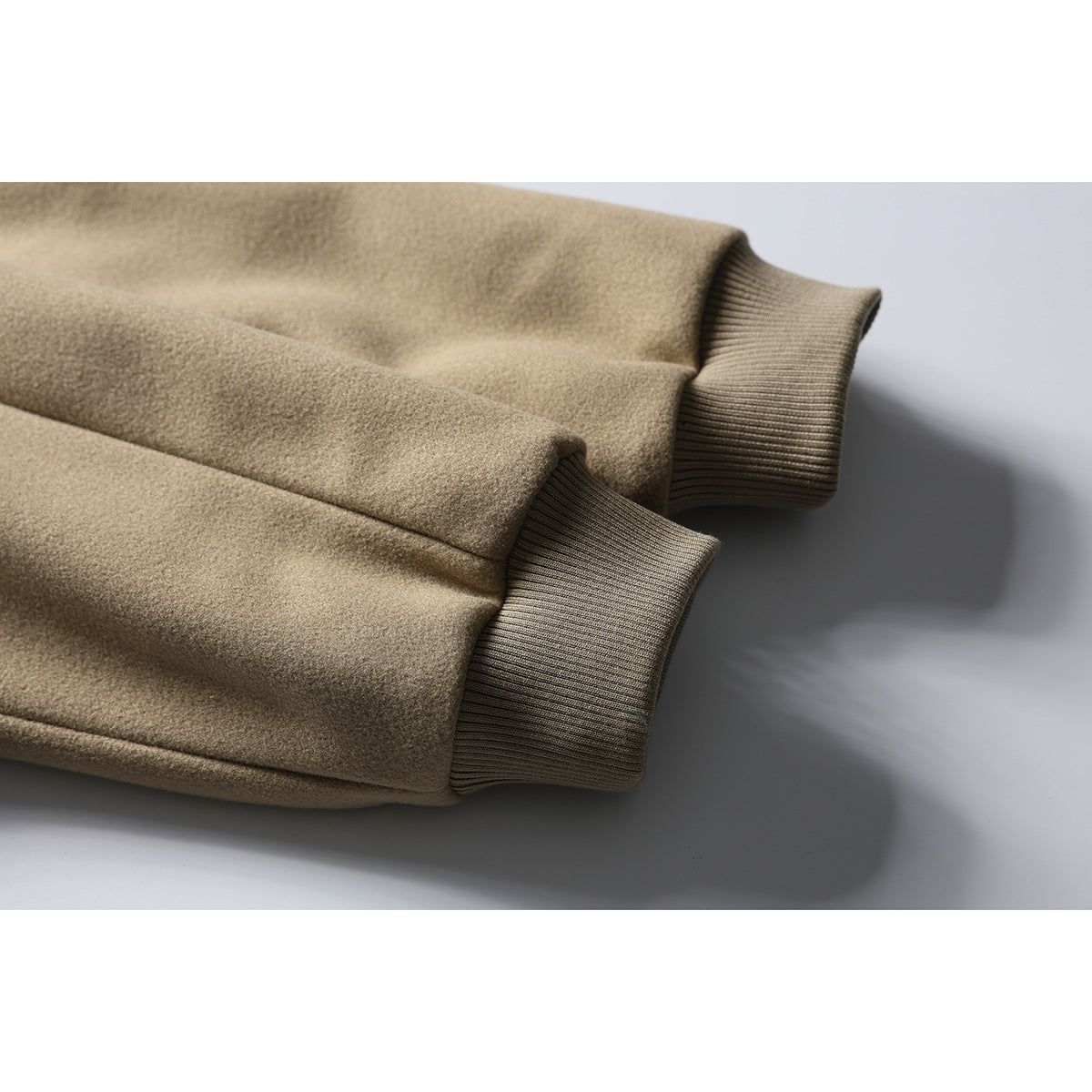 Close-up of the tan jacket's sleeves and ribbed knit cuffs.
