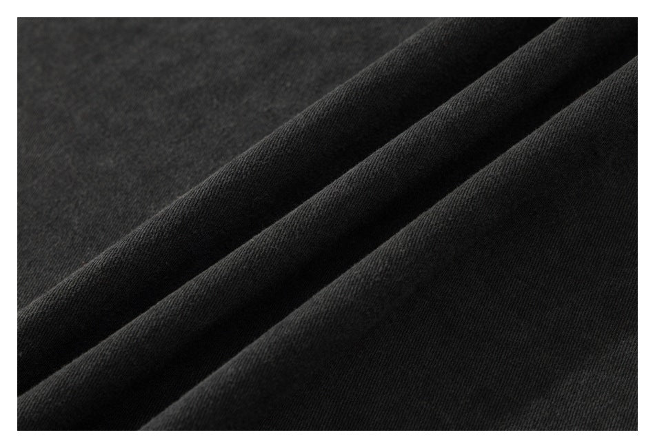 Close-up of black fabric arranged in diagonal folds, showing a fine, slightly textured surface.