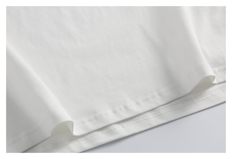 Close-up of the bottom hem and double stitching on a white T-shirt.