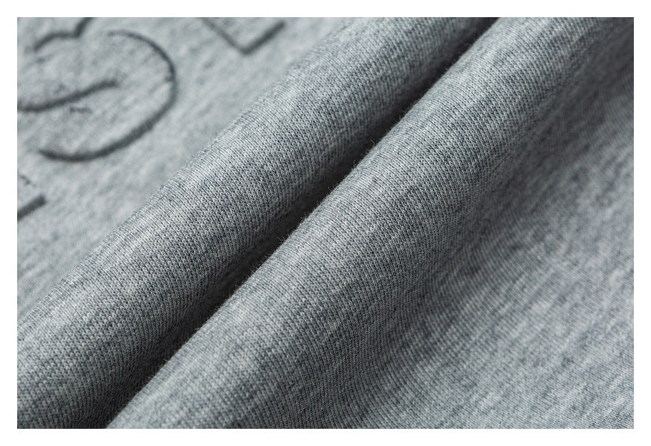 Close-up of the heather gray sweatshirt fabric and part of its raised lettering.