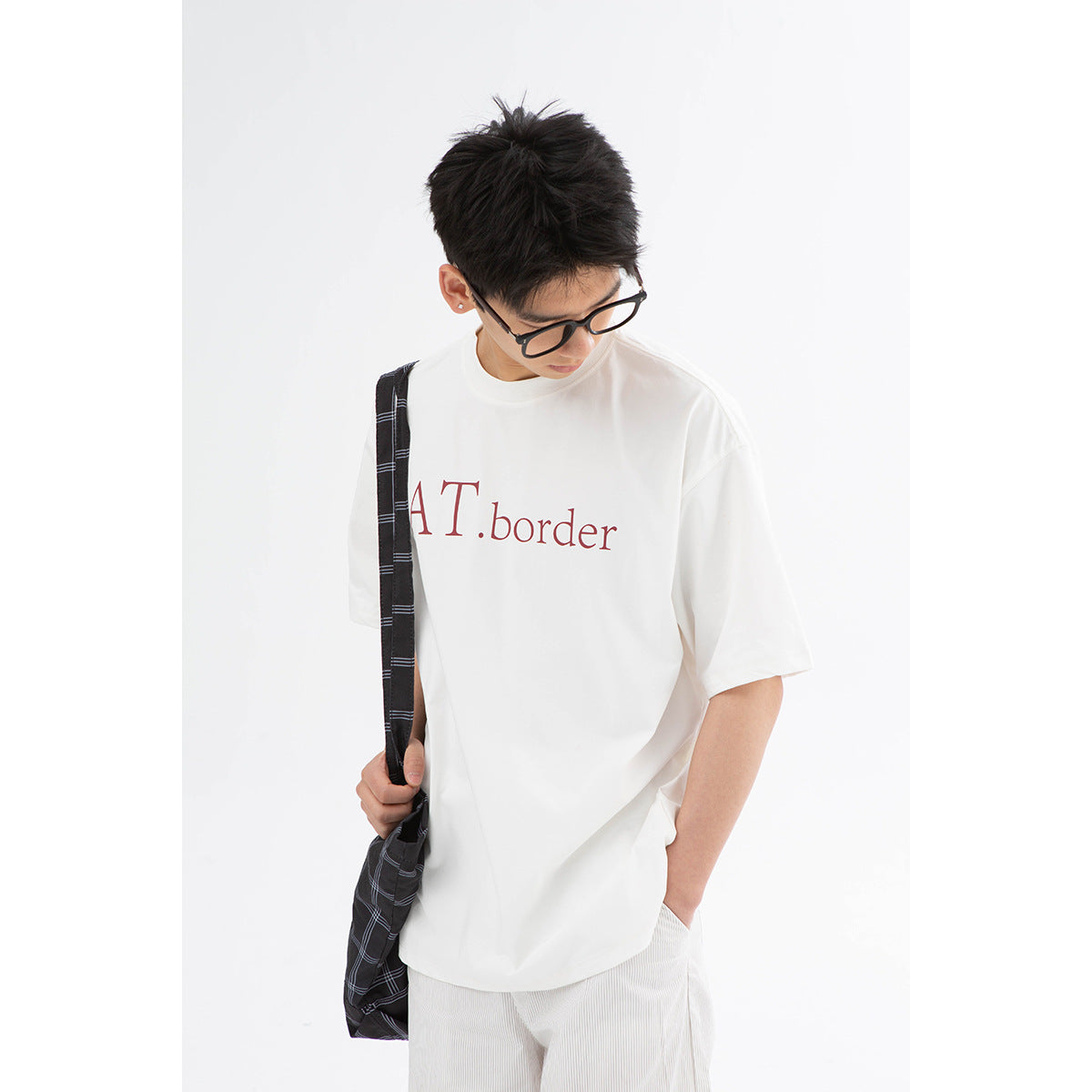 Close view of a model wearing a white oversized T-shirt with red lettering.