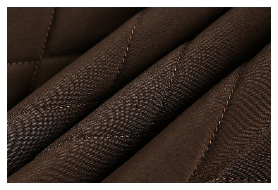 Close-up of dark brown quilted fabric with diagonal padded channels and matching stitching.