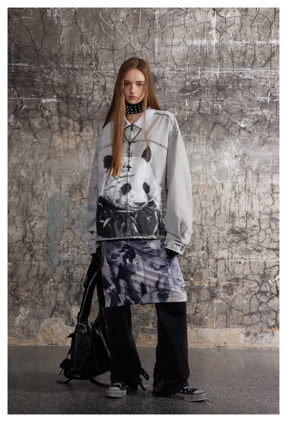 Full-length model wearing a light gray panda-print jacket, photo-collage skirt, and loose black trousers.