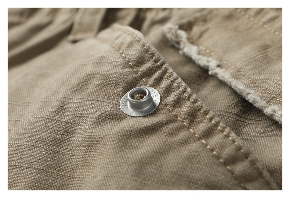 Macro view of a metal eyelet on taupe shorts beside textured fabric and a frayed seam.