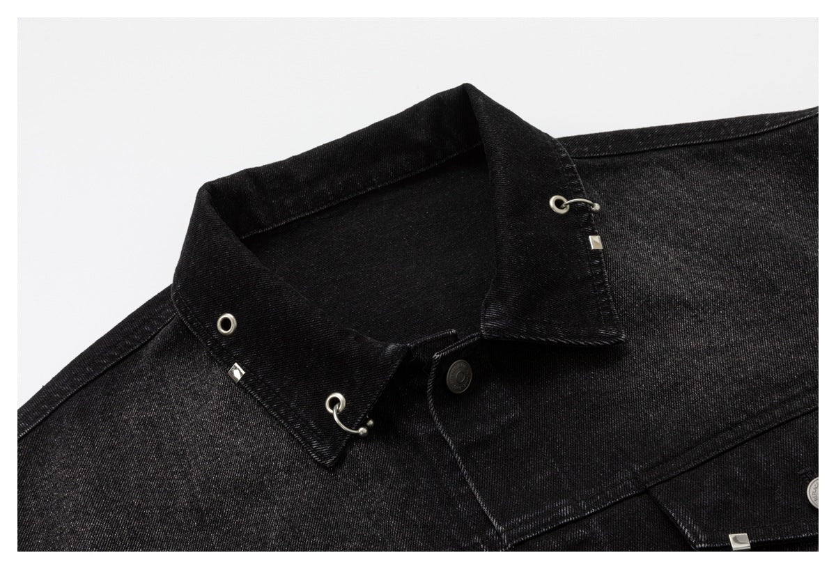 Close-up of the black denim jacket's collar and shoulder, showing silver eyelets and hook details.