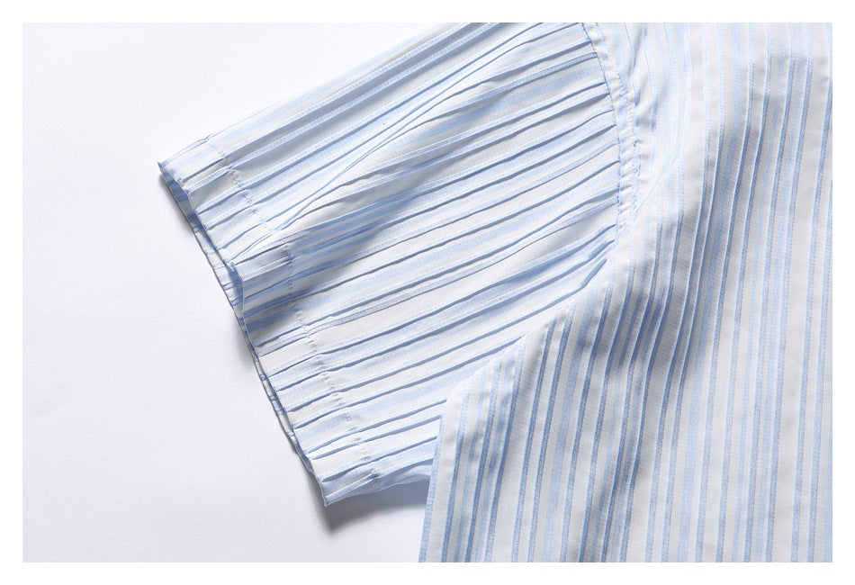 Close-up of the short sleeve and striped body of a white shirt with pale blue vertical stripes.