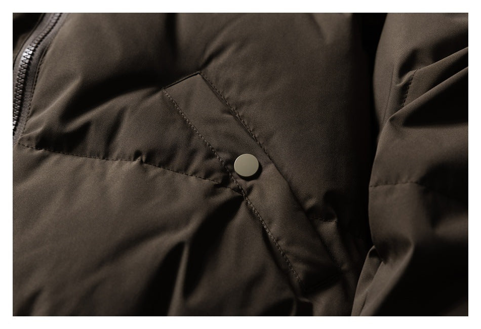 Close-up of a dark brown jacket pocket flap secured with a round snap button.