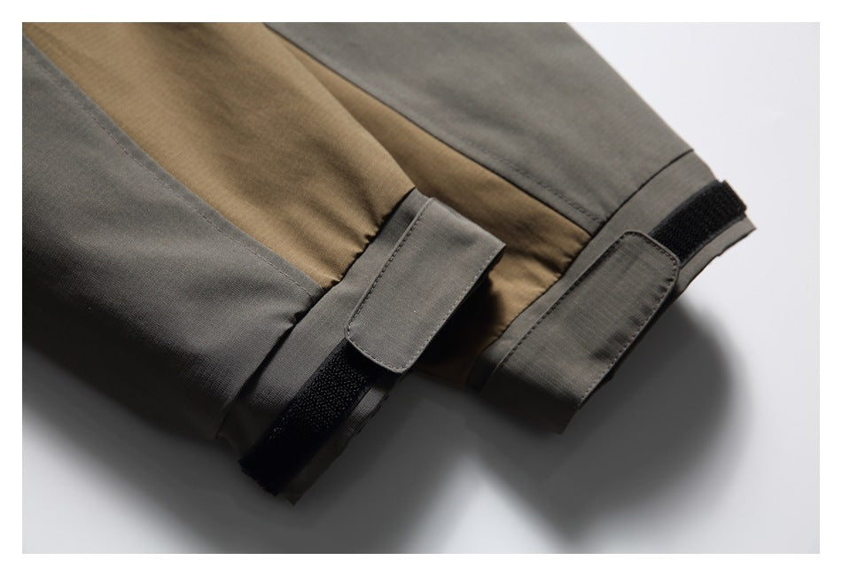 Close-up of gray and brown jacket sleeve cuffs with adjustable hook-and-loop tabs.