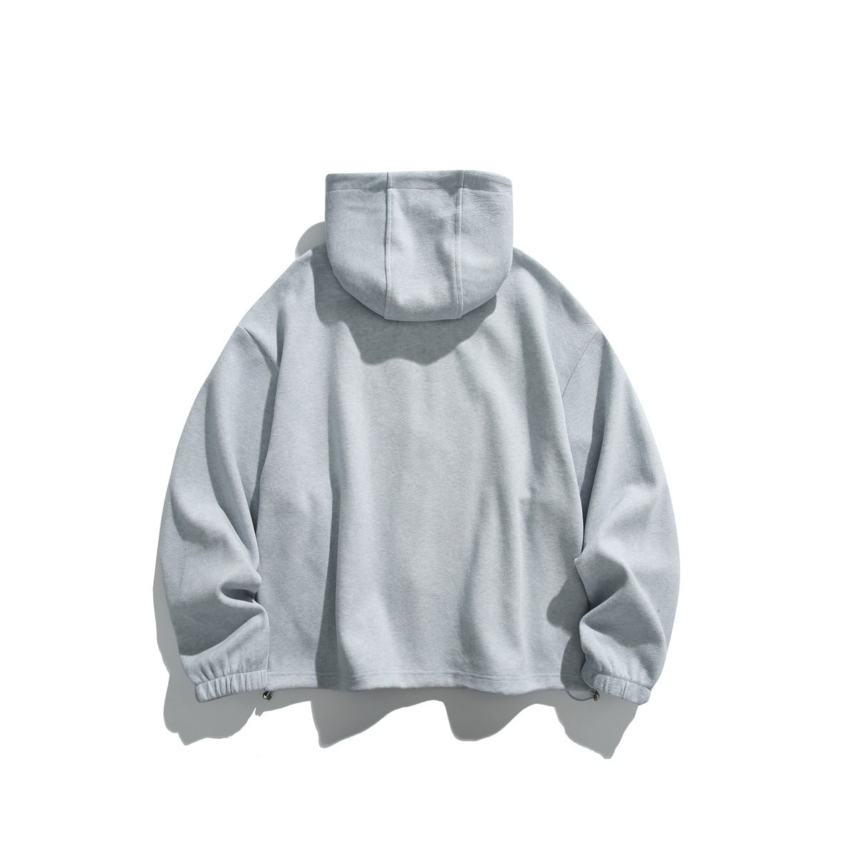 Back view of a pale gray hooded jacket with long sleeves and gathered cuffs.
