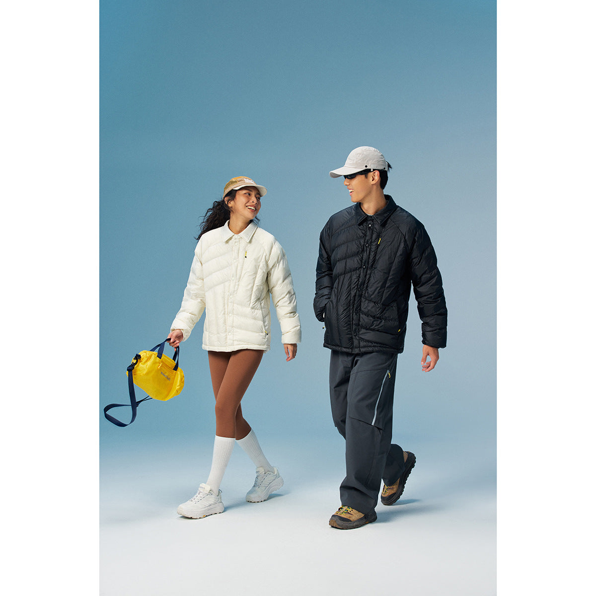 Two models wear white and black quilted jackets with collared fronts and snap closures.