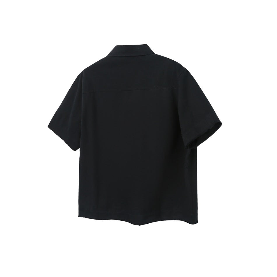 Back view of a black short-sleeve collared shirt with a horizontal yoke seam and raw sleeve edges.