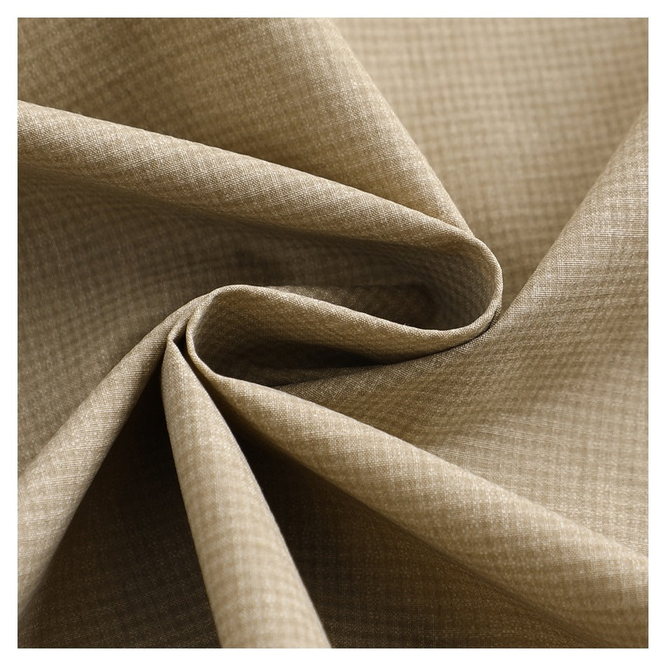 Close-up of beige micro-check shirt fabric gathered into soft folds.