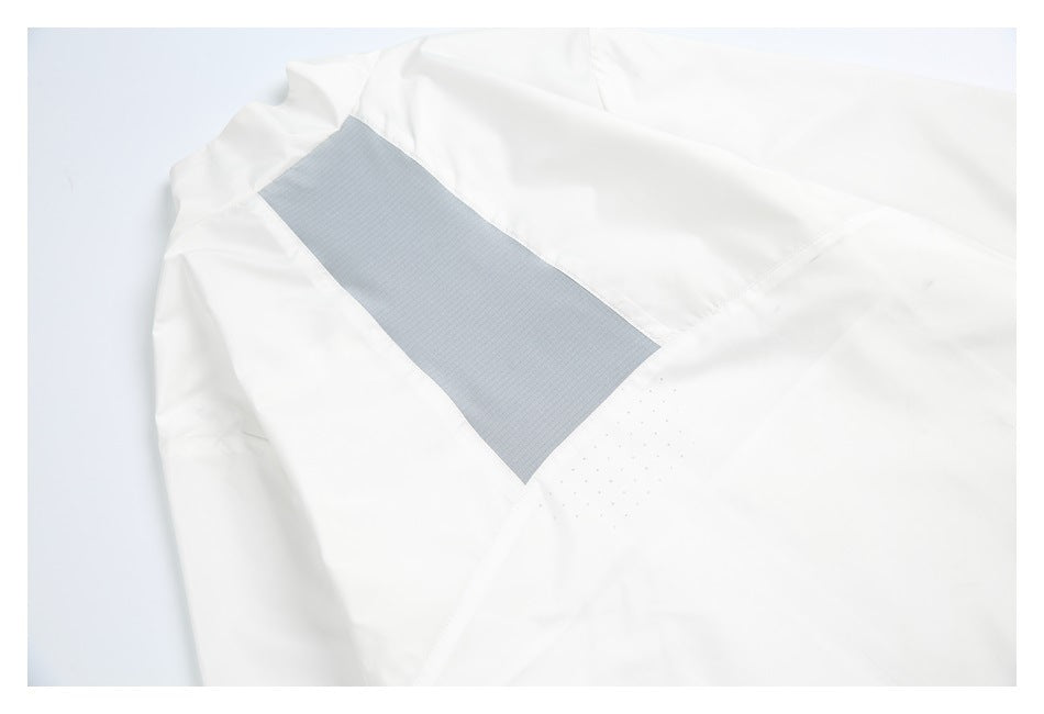 Close-up of a gray vent panel and small perforations on a white garment.