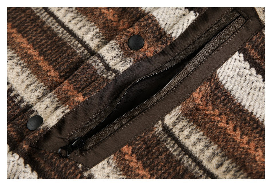 Close-up of a dark zipper and snap buttons on brown, rust, and cream patterned fabric.