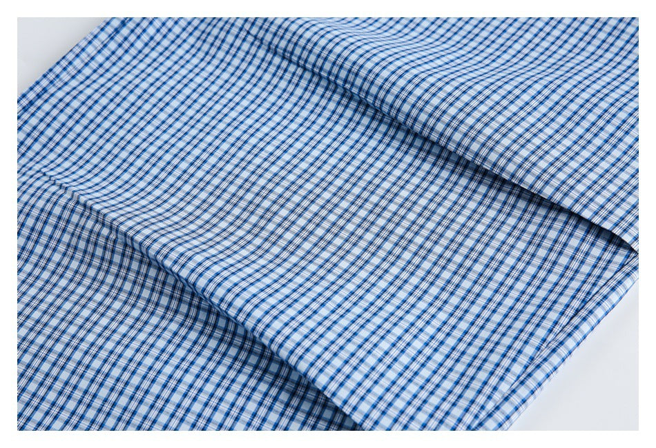Close-up of blue-and-white plaid fabric folded in overlapping layers.