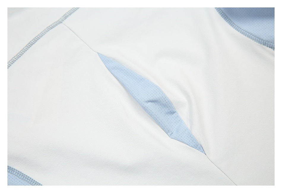 Close-up of a white garment with a pale blue mesh inset and matching overlock stitching.