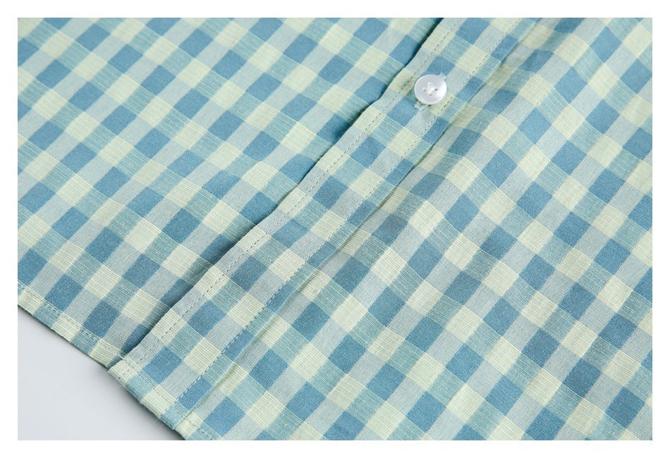 Close-up of the shirt's blue and pale yellow gingham front placket, white button, and lower hem.