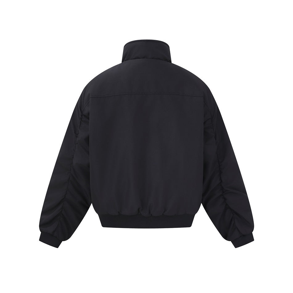 Back view of a black jacket with a tall collar, long sleeves, and a ribbed hem and cuffs.
