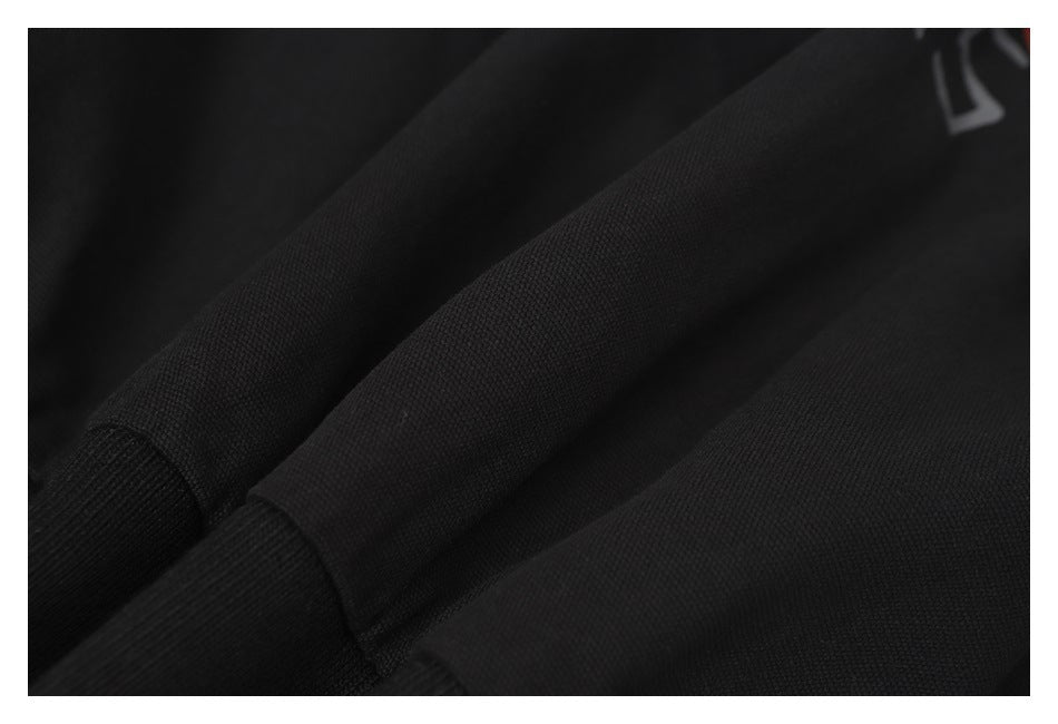 Close-up of black garment fabric with a fine textured surface and a ribbed section.