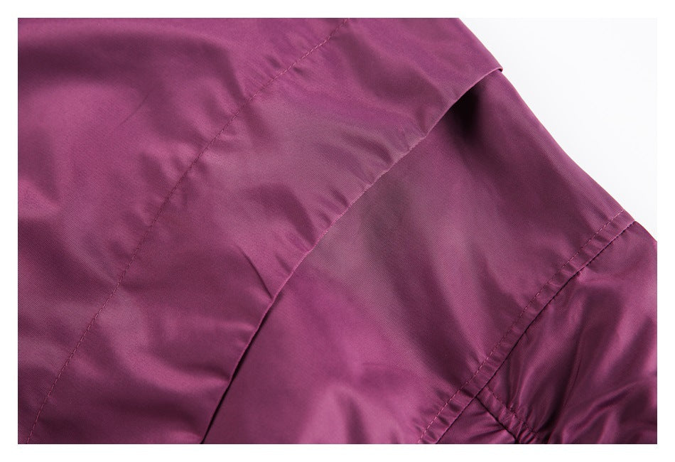 Close-up of the plum jacket's panel seams and folded fabric detail.