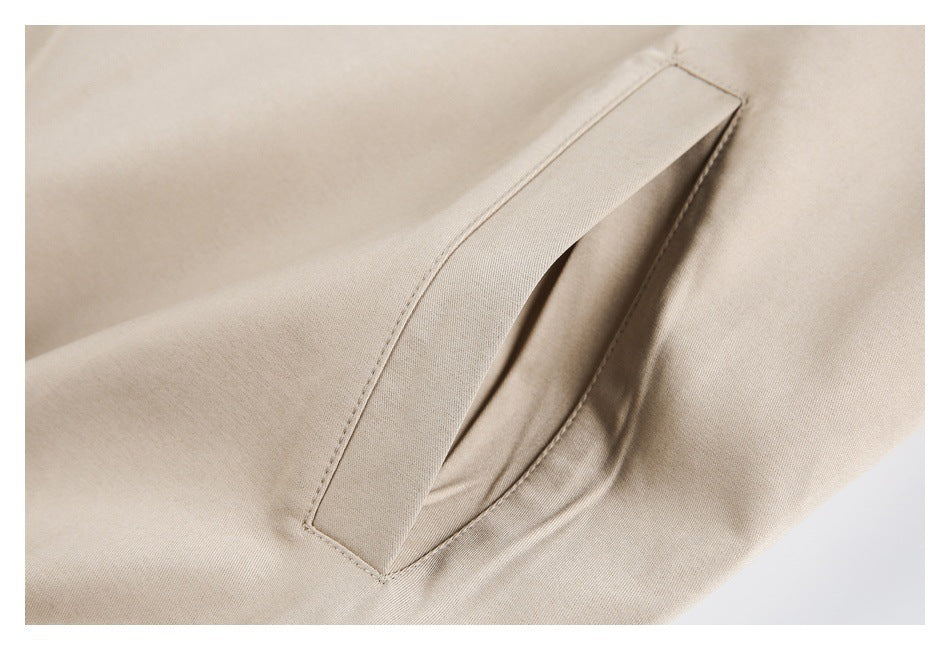 Close-up of a slanted welt pocket on the beige jacket.