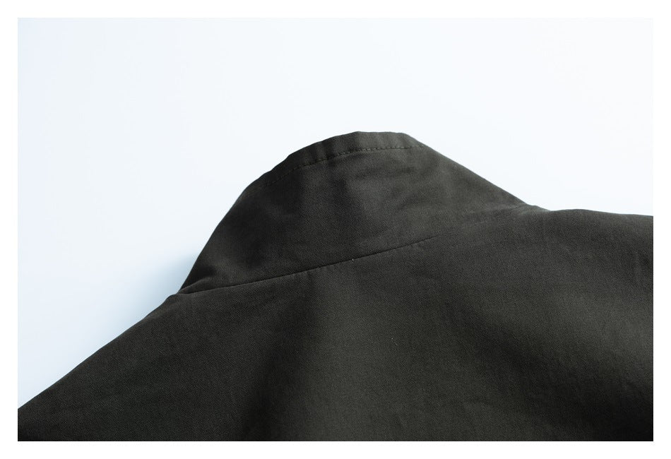 Close-up of the collar and shoulder seam of a dark charcoal garment.