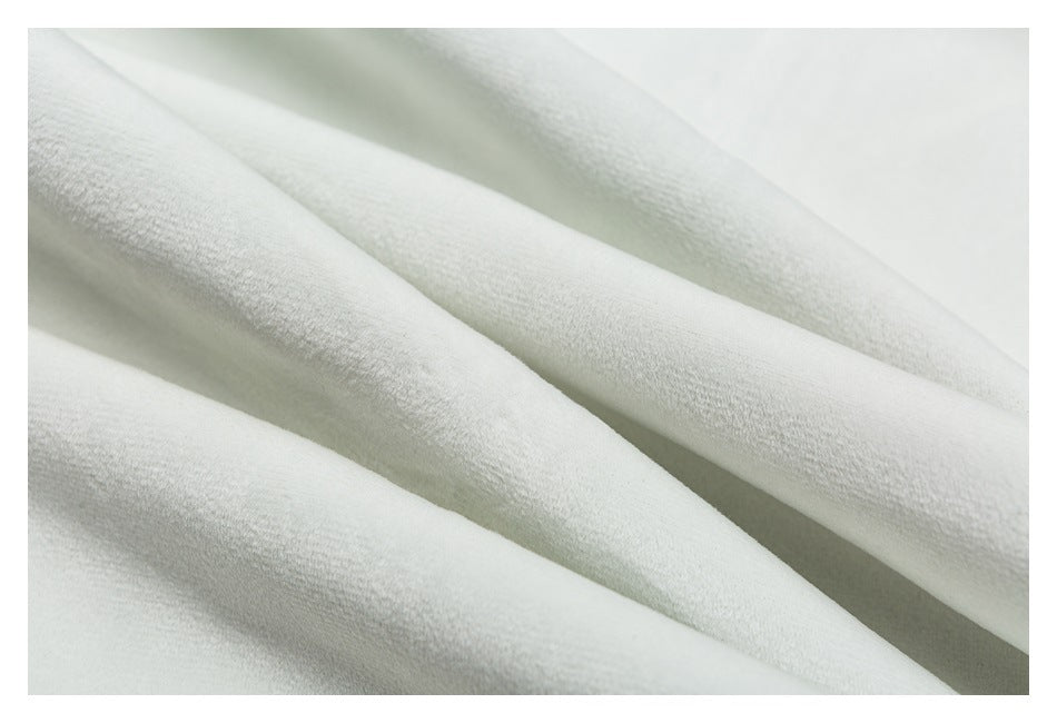 Close-up of folded white garment fabric showing its soft-looking surface and texture.