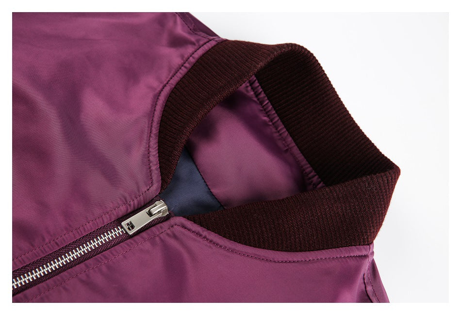 Close-up of a plum bomber jacket's dark ribbed collar and silver front zipper.