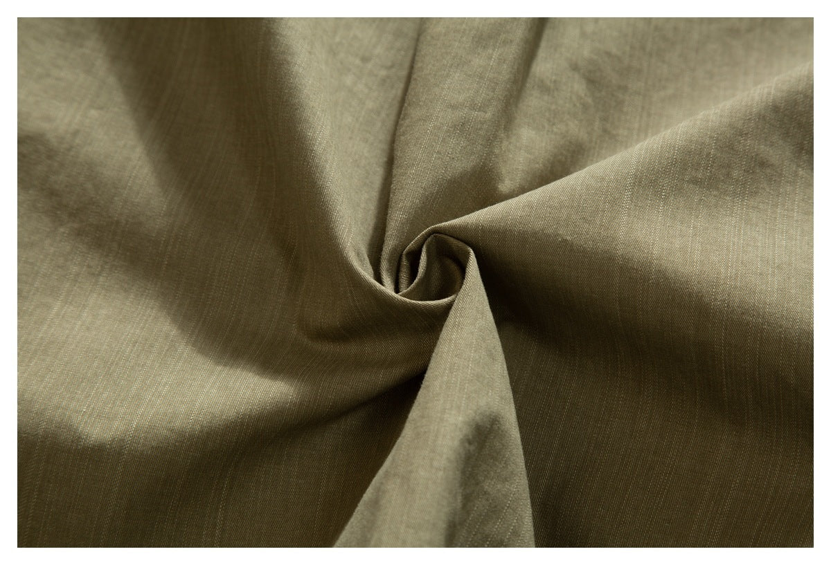Close-up of olive-khaki shirt fabric gathered into a twist, showing its surface and drape.