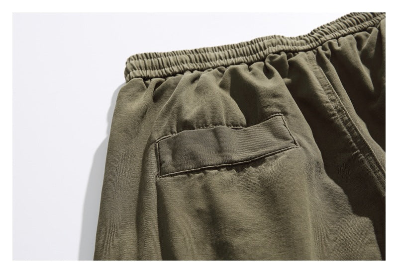 Close-up of an olive shorts back pocket and gathered elastic waistband.