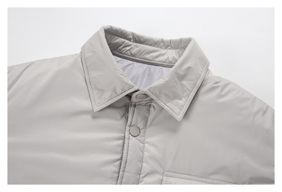 Close-up of a light gray jacket collar, snap-button front placket, and top edge of a chest pocket.