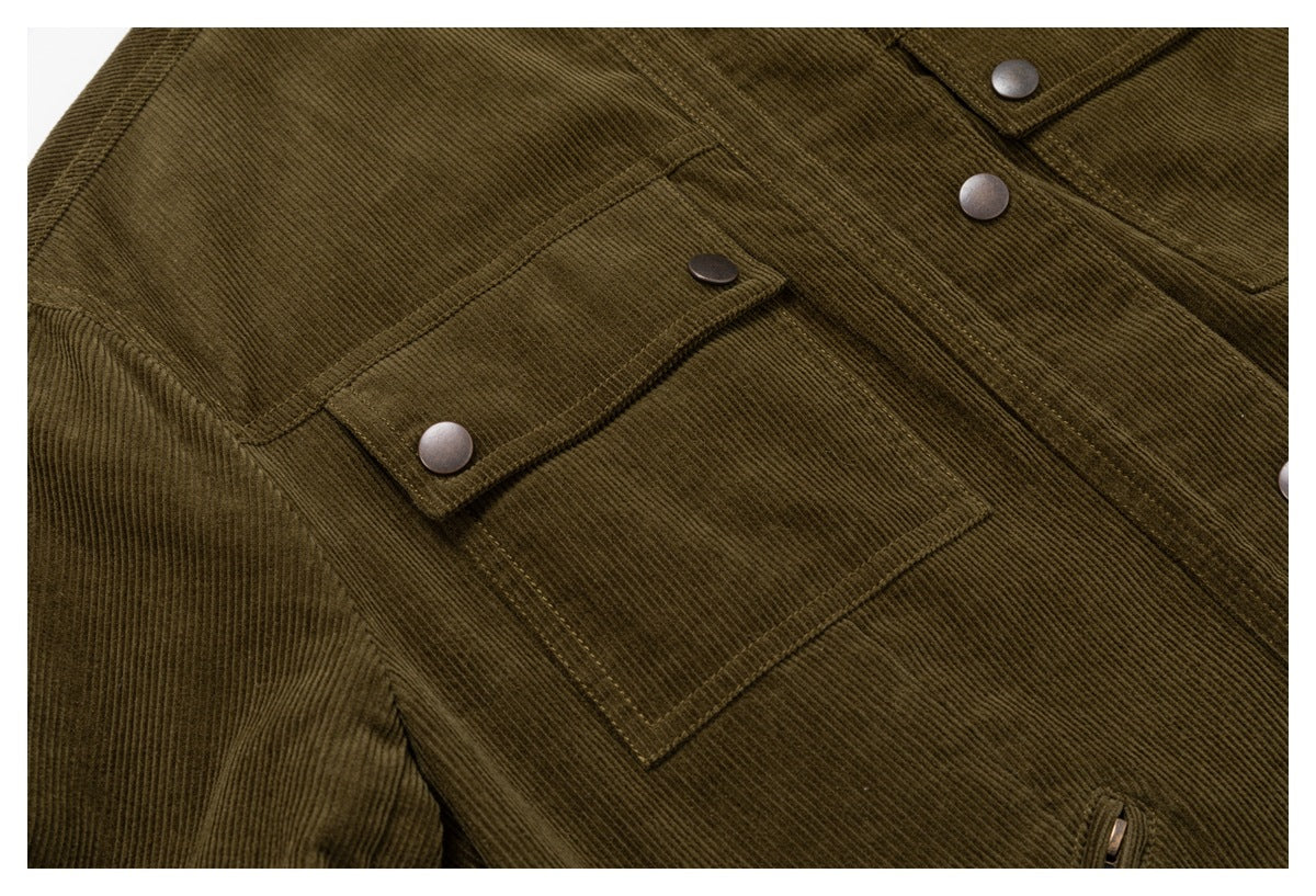 Close-up of an olive corduroy jacket front showing a flap chest pocket, stitching and metal snaps.