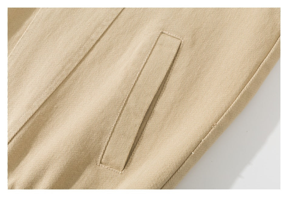 Close-up of a narrow welt pocket on a beige garment.
