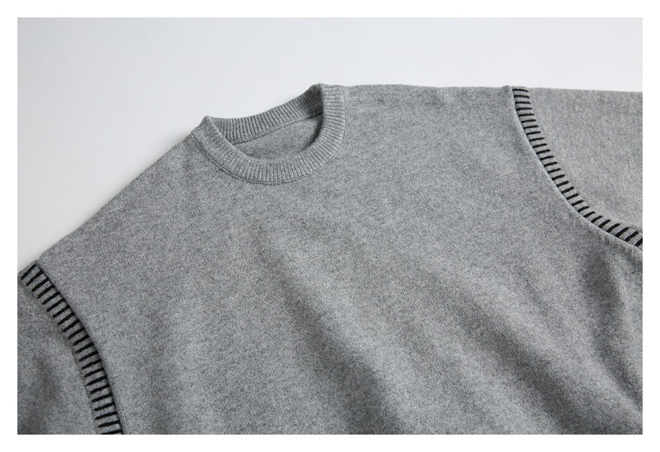 Partial flat-lay front view of a gray crewneck knit sweater with dark stitch accents along the shoulder seams.