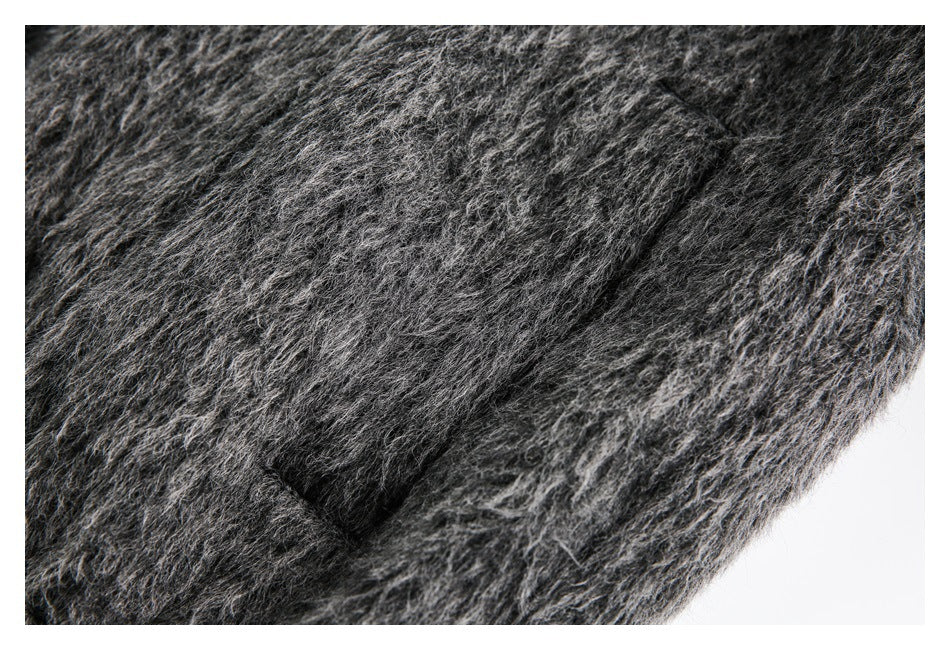 Close-up of shaggy charcoal-gray fabric showing a slanted seam or pocket opening.