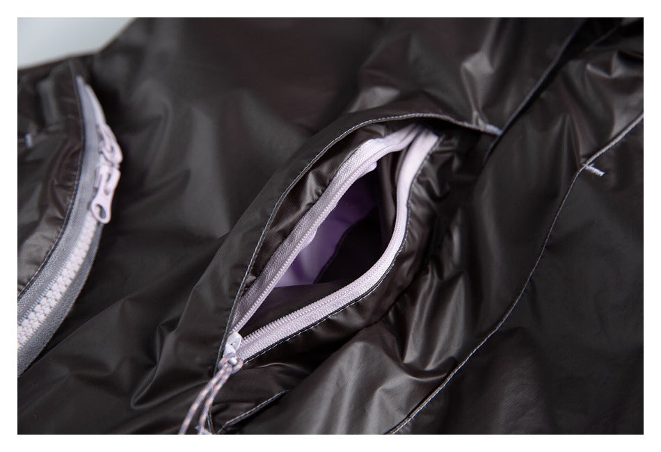Open zip pocket on a black jacket reveals lavender lining and a pale zipper.